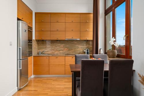 弗罗茨瓦夫Prestige Apartment - Elegant & Quiet Stay 3 rooms 90m2 - AS Home Apartamenty Rynek 508的厨房配有木制橱柜和桌椅