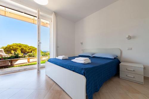 een slaapkamer met een bed en een groot raam bij Villa Marilena in Marina di Casalvelino