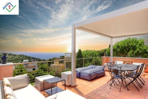 a patio with a table and chairs on a balcony at Villa Irene in Castiglioncello by TuscanyWeGo in Chioma