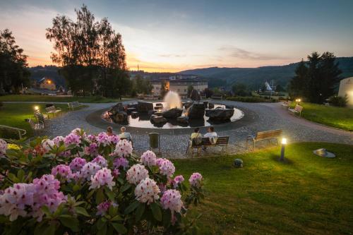 a group of people sitting around a fountain in a park at Kurhotel Bad Schlema in Bad Schlema