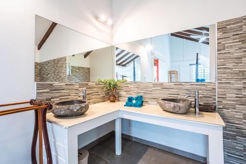 2 lavabos en un baño con espejo en Villasticreole, en Deshaies