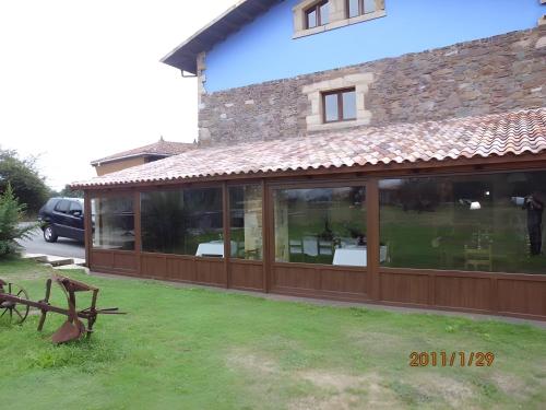 a conservatory with glass doors on the side of a house at Casona Asturiana Los Gamonales in Logrezana