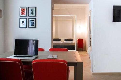 une pièce avec une table avec un ordinateur portable dessus dans l'établissement Re Federico Appartamento Deluxe, à Syracuse