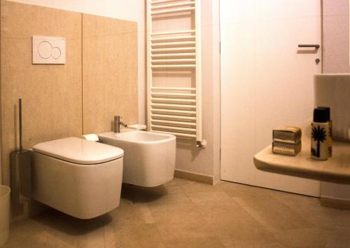 une salle de bains blanche avec toilettes et lavabo dans l'établissement Re Federico Appartamento Deluxe, à Syracuse