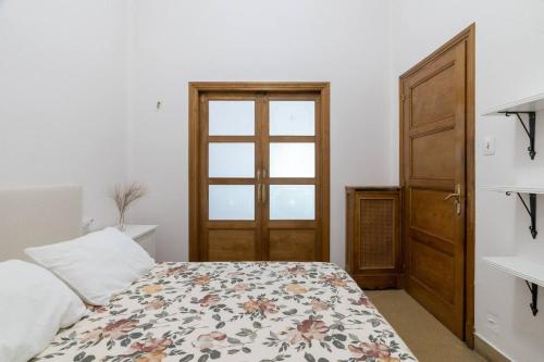 a bedroom with a bed with a floral bedspread and a door at Casa Bogart Apto 5 dormitorios in Ourense