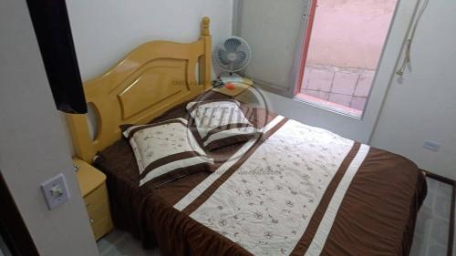 グァラトゥバにあるTriplex near the beach and downtownのベッドルーム1室(ファン付きのベッド1台付)