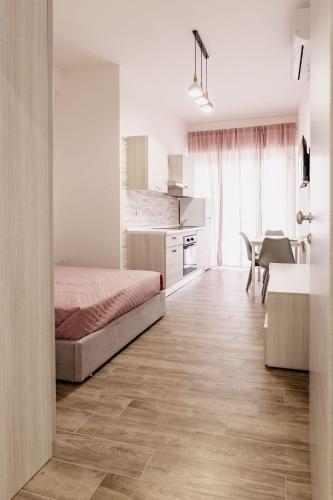 a bedroom with a bed and a kitchen with a table at Vicolo Mediterraneo Apartment in Reggio di Calabria
