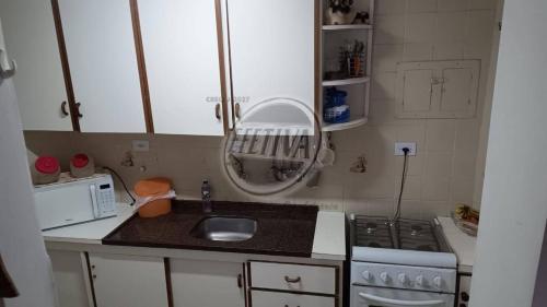 グァラトゥバにあるTriplex near the beach and downtownのシンクとコンロのある小さなキッチン