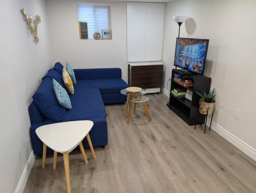 a living room with a blue couch and a tv at Lake-Walk House in Hamilton
