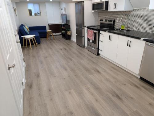 a kitchen with white cabinets and a hard wood floor at Lake-Walk House in Hamilton
