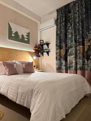 a bedroom with a large white bed and a window at Tiny Square in Nafpaktos