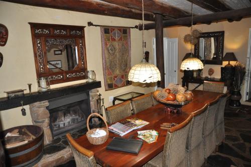 a living room with a table and a fireplace at Gunyatoo Trout Trout Farm & Guest Lodge in Sabie