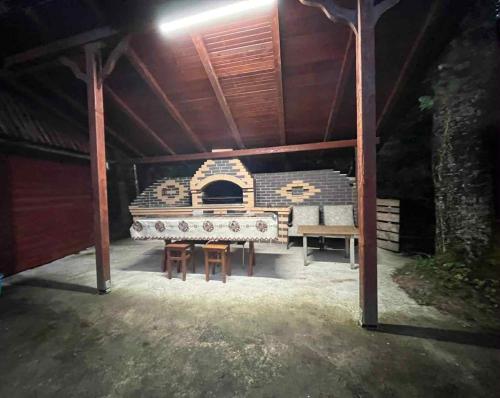 an outdoor grill in a pavilion with a table and benches at Cabana Paltini 