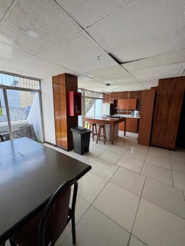 an empty room with a table and a kitchen at Hotel Urban Guest in Estación La Ermita