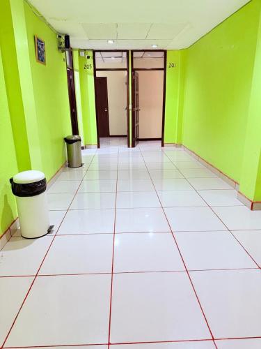 an empty room with green walls and a white tile floor at Hotel Urban Guest in Estación La Ermita