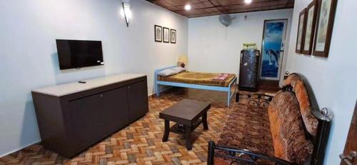 a living room with a tv and a couch and a table at Private Spacious family 1 Bhk Apartment in Arambol in Jāmb