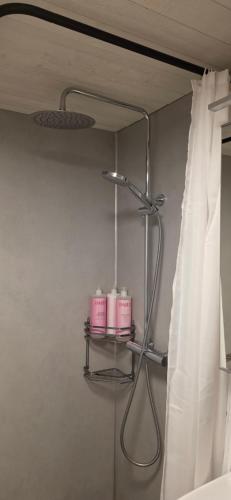 a bathroom with a shower curtain and a shelf with candles at Aurora river cabin in Kiruna