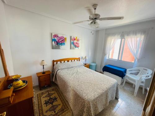 a bedroom with a bed and a chair and a window at Las Gondolas by Alina365 in La Manga del Mar Menor