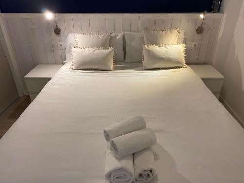 Una cama blanca grande con toallas. en Santelmo,16, en Málaga