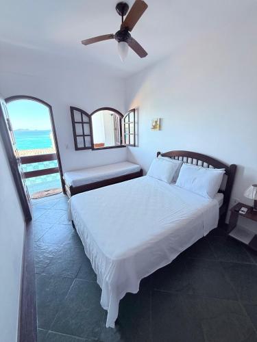 a bedroom with a bed and a ceiling fan at Pousada Vó Nina in Arraial do Cabo