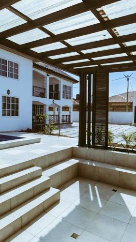 eine Terrasse mit Markise und Treppe vor einem Gebäude in der Unterkunft The Glisson Residence, Adenta in Santeo