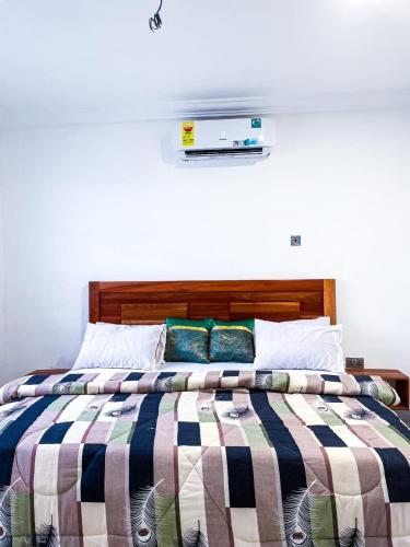 ein Bett mit gestreifter Decke in einem Schlafzimmer in der Unterkunft The Glisson Residence, Adenta in Santeo