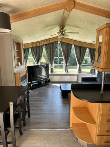 a living room with a ceiling fan and a table and chairs at Ruxley Studios in Orpington