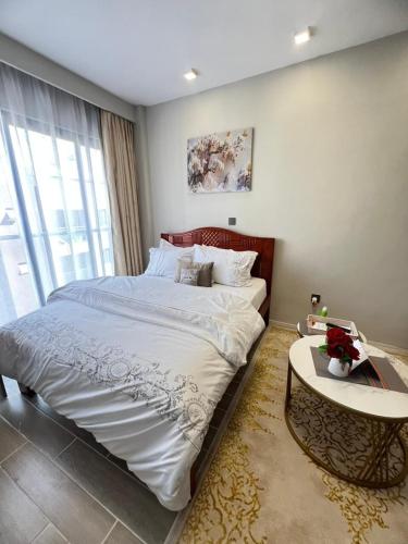 a bedroom with a large bed and a table at Studio near JKIA and SGR Syokimau in Nairobi