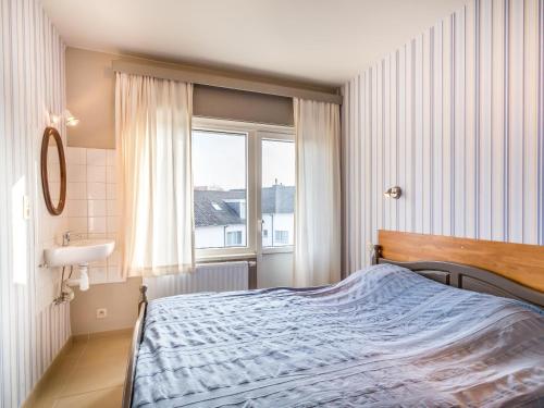 ein Schlafzimmer mit einem Bett, einem Waschbecken und einem Fenster in der Unterkunft Argenteuil eerste in Galopen