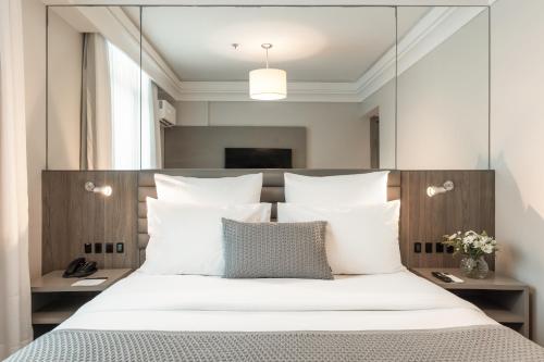 a bedroom with a large mirror above a bed at Blue Tree Premium Florianópolis in Florianópolis