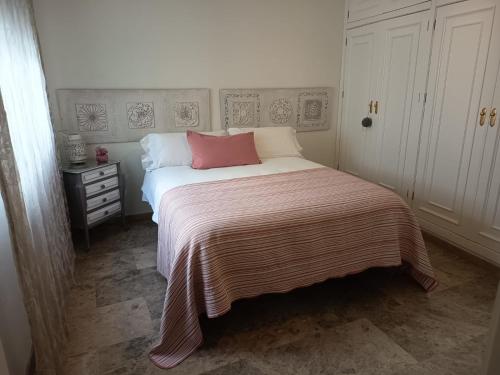 een slaapkamer met een bed met een roze kussen erop bij Capitulares 2 in Córdoba