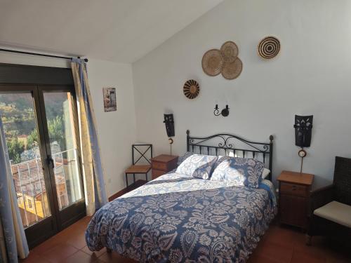a bedroom with a bed and a sliding glass door at La Libélula de Valles in Puebla de Vallés