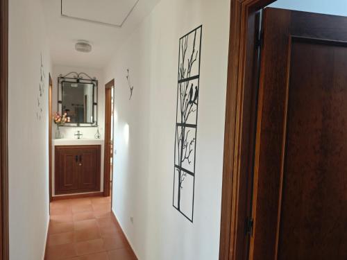 a hallway with a door and a mirror on a wall at La Libélula de Valles in Puebla de Vallés