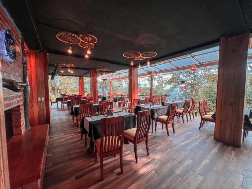 a dining room with tables and chairs and windows at El Toro en Bicicleta in San Miguel de los Bancos