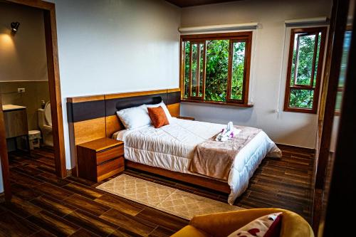 a bedroom with a bed and two windows at El Toro en Bicicleta in San Miguel de los Bancos