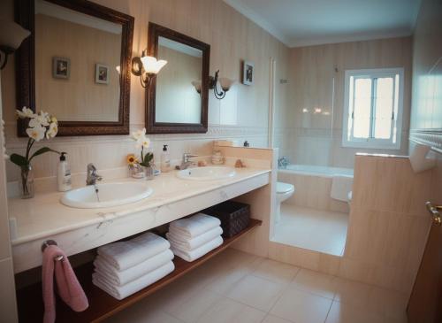 a bathroom with two sinks and a tub and a mirror at Costa Dorada Villa - Pool BBQ Beach 5min in Calafell