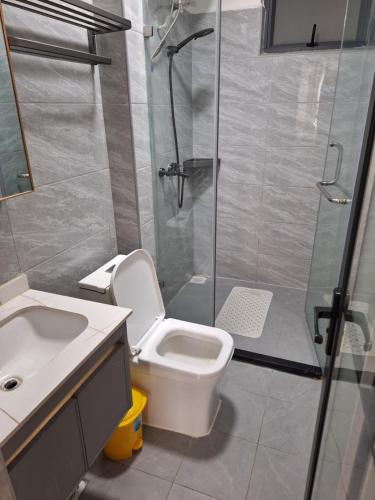 a bathroom with a shower and a toilet and a sink at Golden Mango Heights - Urban Family Suite - One Bedroom Apartment - Restaurant, Workspace, City Views, Fast WiFi, Sauna, Fitness Facilities, Secure Parking And Kids Play Area in Nairobi