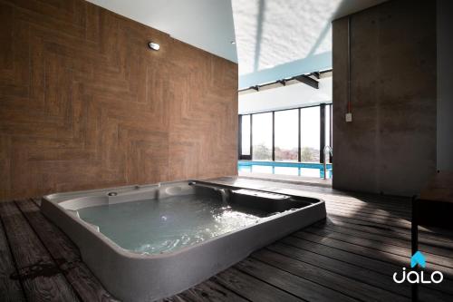 a large bath tub in a room with a wooden floor at 72Hub Apartments By Jalo in Bogotá