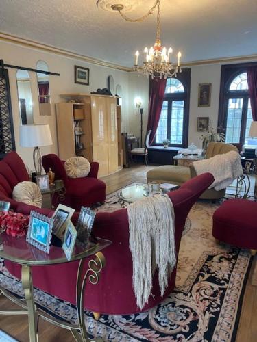 a living room with red chairs and a table at Mill Creek Mansion in Youngstown