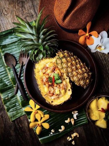 a plate of food with a pineapple on a table at KAS Luxury Hotel in Ho Chi Minh City