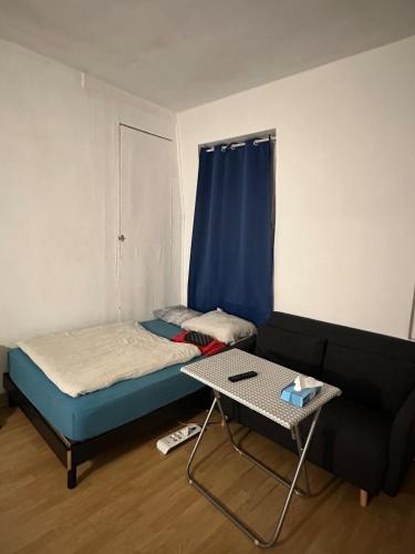 a small room with a bed and a table at Appartement Lumineux, à 5 minutes de Paris in Asnières-sur-Seine