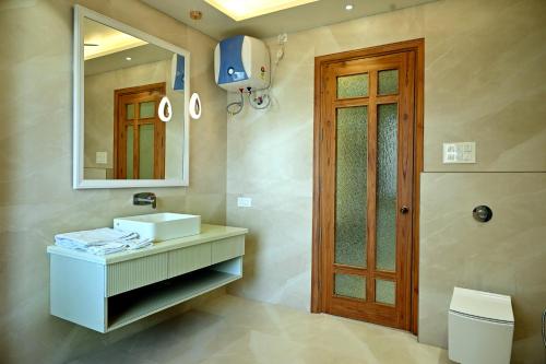 a bathroom with a sink and a mirror and a toilet at FLORENTINO The Luxury Villa in Amritsar