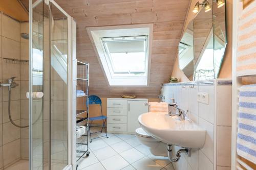a bathroom with a sink and a toilet and a window at Ferienwohnung Obstwiese in Hergensweiler