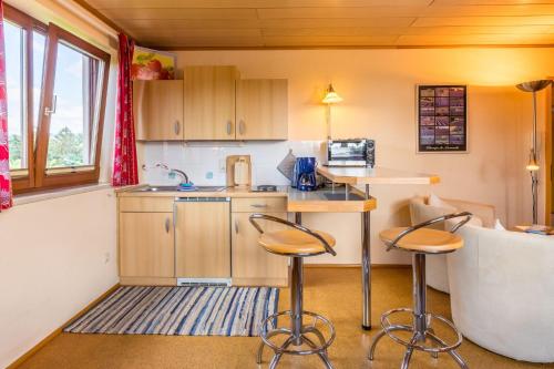 a kitchen with two bar stools in a room at Ferienwohnung Obstwiese in Hergensweiler