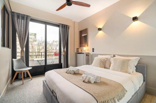 una camera da letto con un letto grande con una grande finestra di Stylish apartment with balcony & lift a Parigi