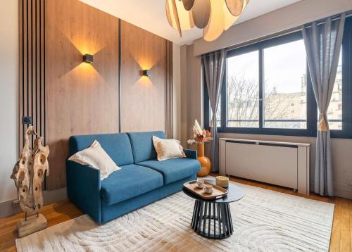 un soggiorno con un divano blu e un tavolo di Stylish apartment with balcony & lift a Parigi