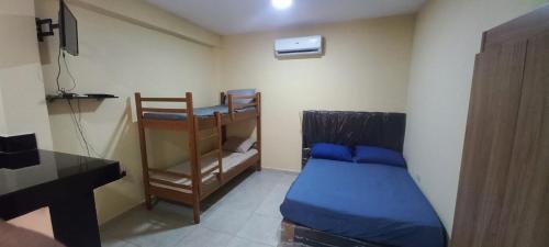 a bedroom with a bunk bed and a desk at Hospedaje San Cosme y Damián in Zarate Isla