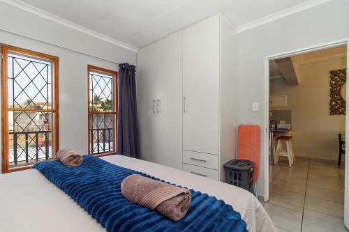 a bedroom with a large bed with a blue blanket at The Bridge, Apartment 67 in St Lucia