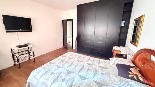 a living room with a bed and a tv at Habitación 2 en Villa Mariaclaudia in Macas