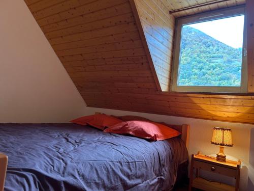 a bedroom with a bed and a large window at Chalet D-LYS in Cauterets